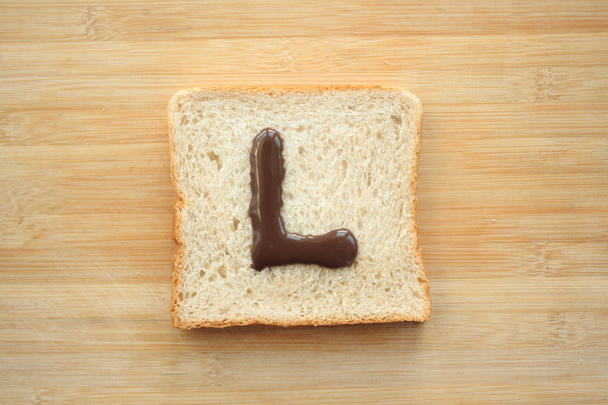 Alfabeto desenhado em fatias de pão
 - Foto, Imagem