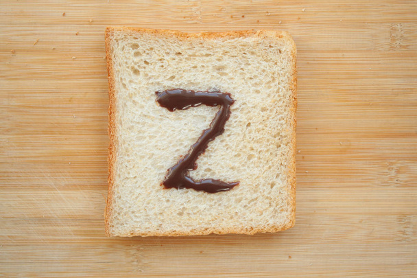Alphabet auf Scheibe Brot gezeichnet - Foto, Bild