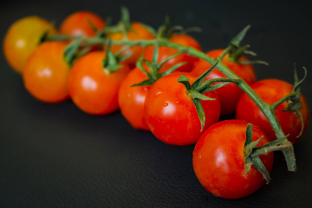 Wiśniowe pomidory z wody spadnie na tle ciemnej skóry z miejsca kopii - Zdjęcie, obraz