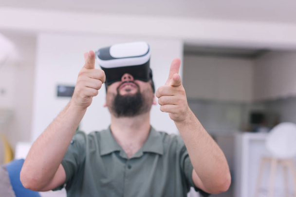 handsome hipster man with beard trying vr glasses at modern home - Photo, image