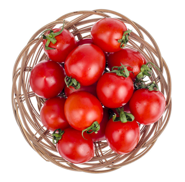 Small red ripe tomatoes in wicker wooden bowl. Studio Photo - Fotoğraf, Görsel