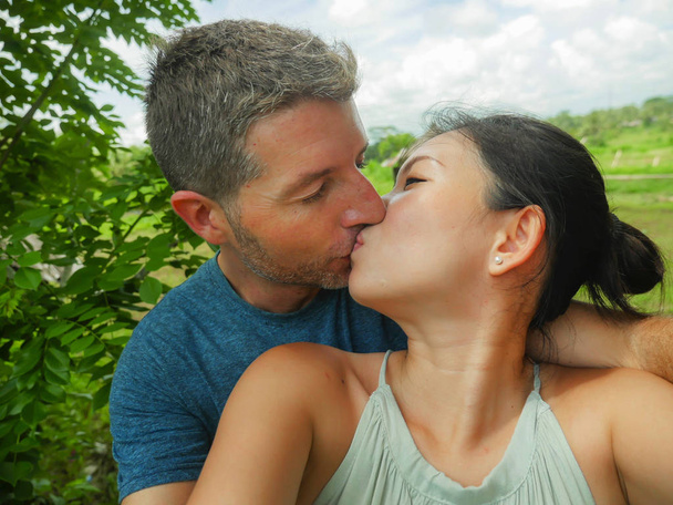 όμορφη νεαρή όμορφη και ευτυχισμένη μικτής εθνότητας ζευγάρι Ασίας κινεζική γυναίκα και λευκός άνθρωπος στην αγάπη λήψη selfie φωτογραφία σε εξωτερικούς χώρους απολαμβάνοντας ρομαντικές διακοπές ταξίδι στην τροπική μήνα του μέλιτος διακοπές - Φωτογραφία, εικόνα