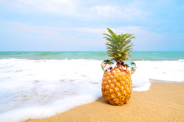 Hipster ananas bir kumlu plajda güneş gözlüklü. yaz moda kavramı. Vintage renk tonu filtre efekti - Fotoğraf, Görsel