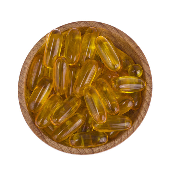 Žlutá vitamín měkké želatinové tobolky s mastnou drog a nutriční doplněk, dřevěné lžíce, naběračka. Studiové fotografie - Fotografie, Obrázek