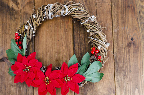 homemade christmas wreath with red flowers on wooden background, place for text. Studio Photo - Photo, Image