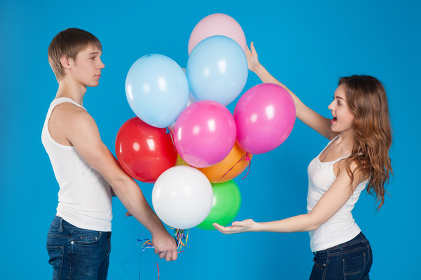 Young boy presenting balloons to a girl. - Фото, зображення