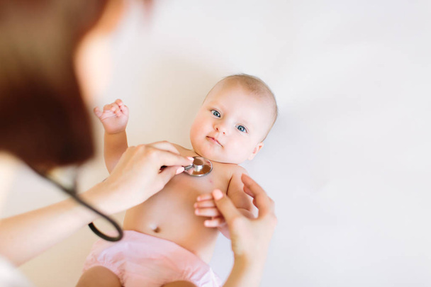 Doctor using a stethoscope to listen to baby's chest checking heart beat. - Foto, Bild