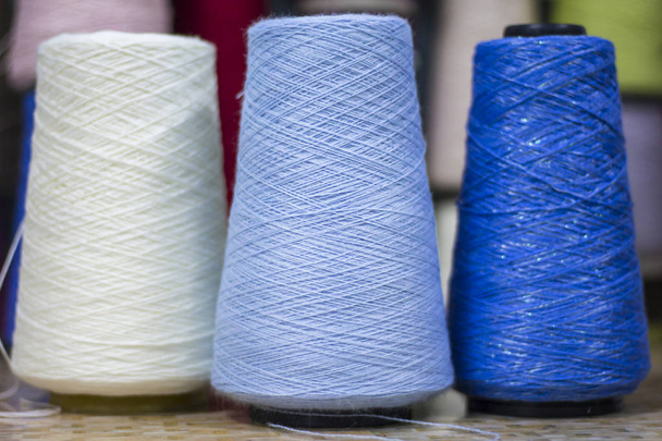 three reels of two blue shades of yarn and one white - Zdjęcie, obraz