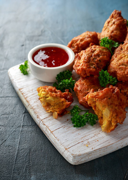 Crispy onion bhajis with sweet chilli sauce on white wooden board - Photo, Image