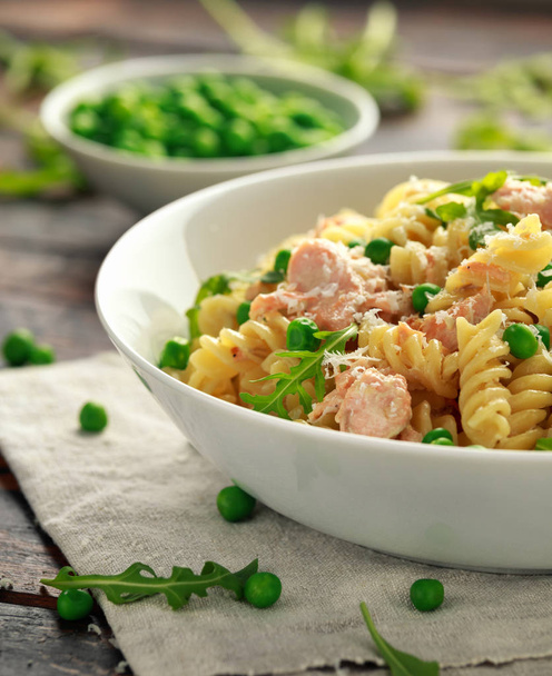 Homemade Pasta fusilli with salmon, green peas, parmesan cheese and lemon. close up. healthy food - Foto, imagen