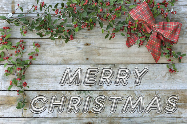 静物と木製の背景、クリスマス カードと年賀はがき。クリスマス タイム。「メリー クリスマス」は、緑の葉と赤い漿果を持つ赤いネクタイをチェック. - 写真・画像