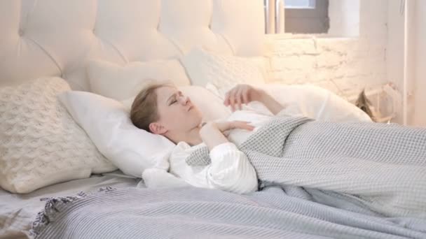 Niespokojne zakłócony młoda dziewczyna stara się spać w łóżku - Materiał filmowy, wideo