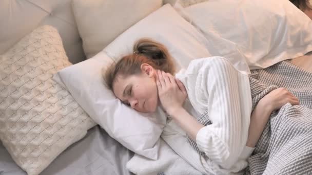 Вид зверху молода дівчина з біль у шиї прокладки в ліжку - Кадри, відео