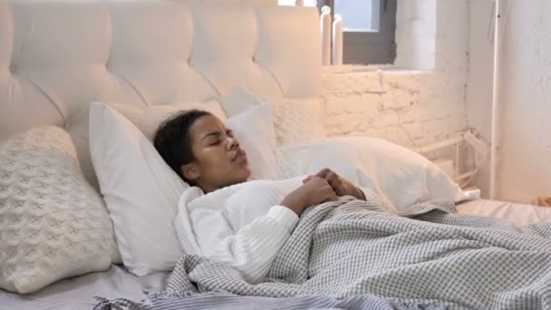Beteg fiatal afrikai lány köhögés az ágyban alvás közben - Felvétel, videó