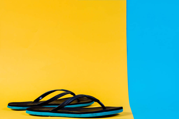 黒と緑フリップフ ロップ、夏セット。夏、来る概念です。シンプルなスタイル、シンプルな写真。黄色、ピンクとブルーのパステル カラーの背景. - 写真・画像