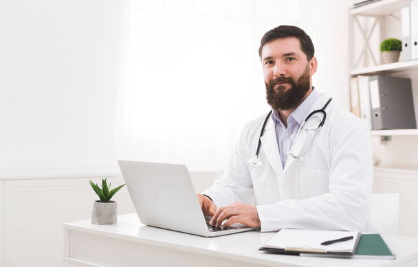 Doctor working with laptop computer in office - Photo, Image