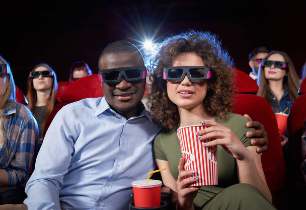 Couple of afro man and brunette woman in cinema. - 写真・画像