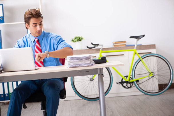 Egy fiatal üzletember biciklivel jár az irodába. - Fotó, kép