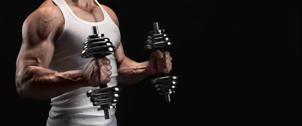 Strong athletic man with dumbbell showes muscular body - Fotoğraf, Görsel