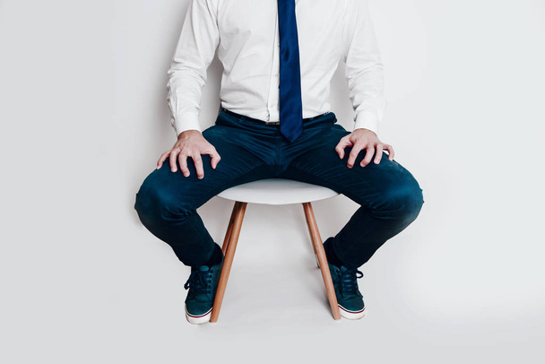 Hombre molesto y estresado vestido con camisa y corbata sentado en una silla. Concepto de nerviosismo antes de la entrevista de reclutamiento. Concepto de recursos humanos. Difícil conversación con el supervisor
. - Foto, Imagen