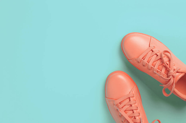 Pair of coral shoes on blue background. - Photo, Image