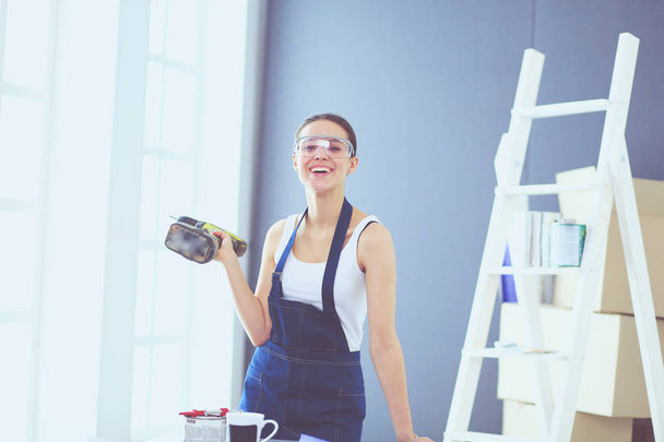 Worker woman with drill standing in new home. - Foto, Imagen
