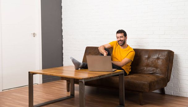 Homem com seu laptop em uma sala apertando as mãos para fechar um bom negócio
 - Foto, Imagem