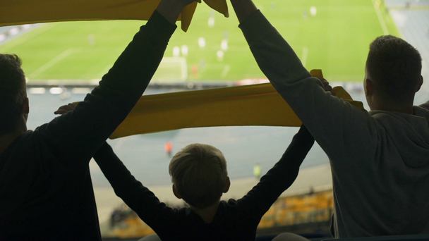 Dospělý a dítě fotbaloví fanoušci zvýšit šátky, příslušenství pro skutečné klub fanoušků - Záběry, video