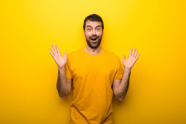 Человек в изолированном ярко-желтом цвете с удивлением и шокированным выражением лица
 - Фото, изображение