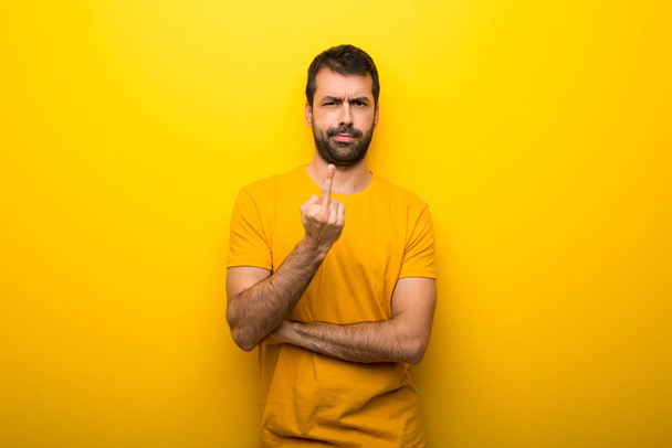 Человек на изолированном ярко-желтом цвете делает жест рога
 - Фото, изображение