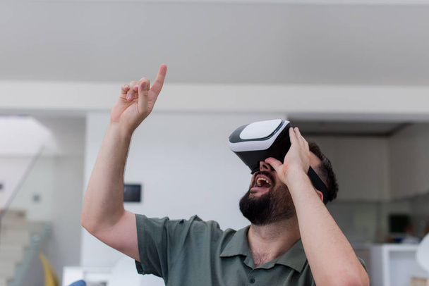 handsome hipster man with beard trying vr glasses at modern home - Foto, Bild