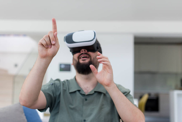 handsome hipster man with beard trying vr glasses at modern home - Foto, imagen