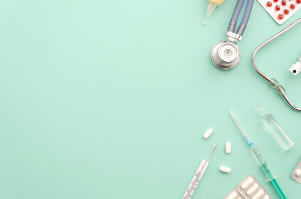 medizinisches oder Gesundheitskonzept. Stethoskop und Medikamente. Attrappe auf blauem Hintergrund. flache Lagesicht. - Foto, Bild