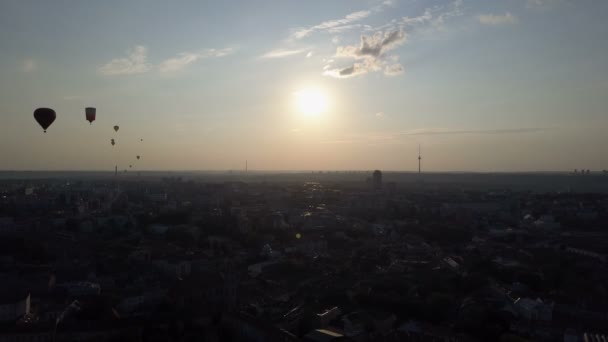 Vista aérea de balões de ar quente sobre a cidade de Vilnius, Lituânia. Balões de ar quente flutuando sobre a cidade ao amanhecer
. - Filmagem, Vídeo