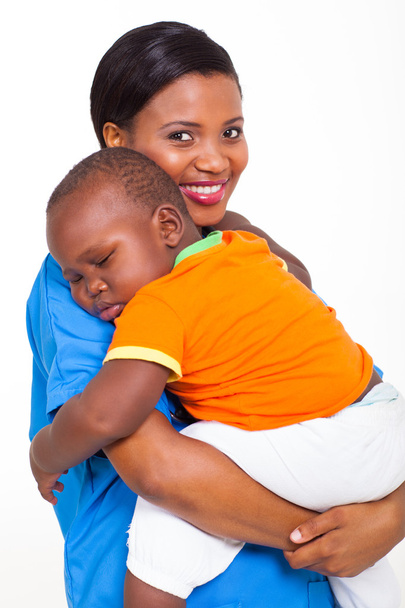 portrait of young african nurse carrying sleeping baby boy - Foto, Imagen