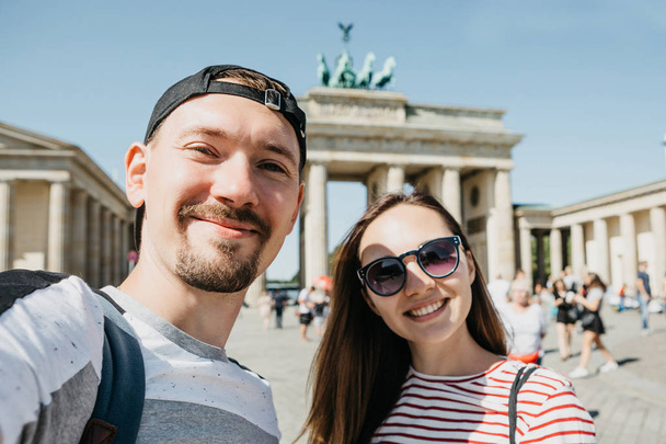 Young couple making selfie against the background of the Brandenburg Gate in Berlin. - Photo, image