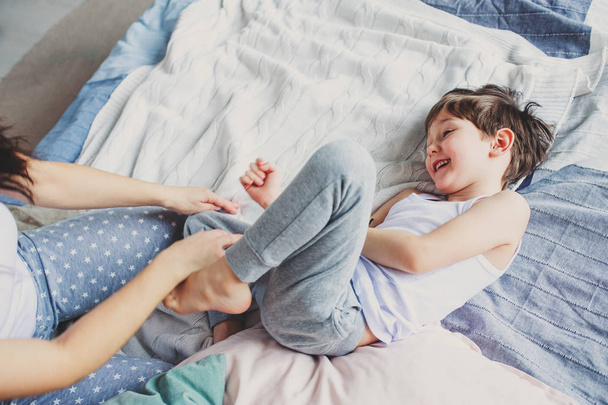 happy mother and child son fooling and playing in bed in the morning. Family relations, casual lifestyle series.  - Fotografie, Obrázek