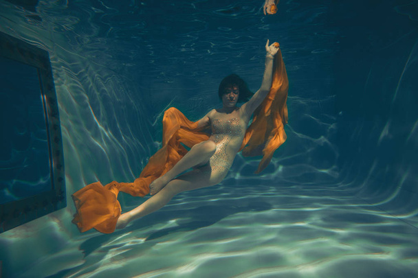 χαριτωμένο σπορ κορίτσι κολυμπάει υποβρύχια ως ένα μόνο ελεύθερος δύτης - Φωτογραφία, εικόνα