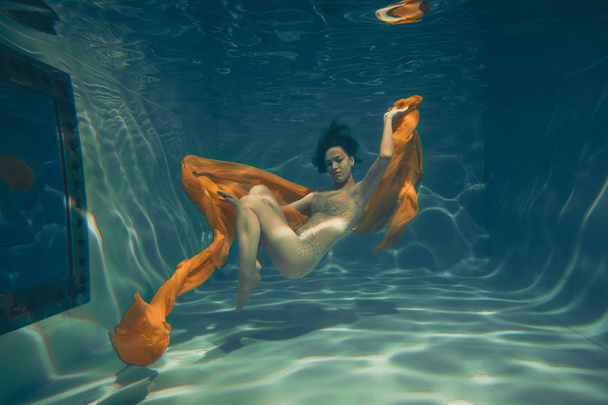 Nettes sportliches Mädchen schwimmt als Freitaucherin allein unter Wasser - Foto, Bild