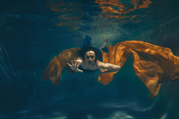 cute sporty girl swims underwater as a free diver alone - Photo, Image
