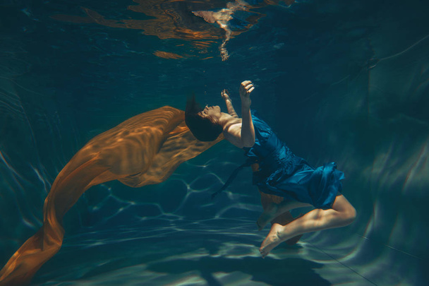 cute sporty girl swims underwater as a free diver alone - Photo, Image