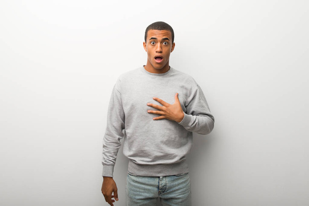 African american man on white wall background surprised and shocked while looking right - Foto, Imagem