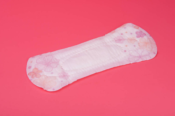 katoen medische handdoek of pad voor vrouwen kritieke dagen op roze achtergrond. Verzorging en bescherming. - Foto, afbeelding