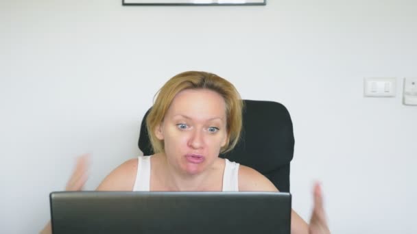 Женщина, сидящая за столом с ноутбуком, злая и раздраженная, ругается. Человеческие эмоции. интернет-зависимость
. - Кадры, видео