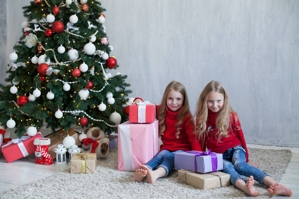 two small girls blonde in red dress at Christmas gifts new year holiday - Foto, Imagen