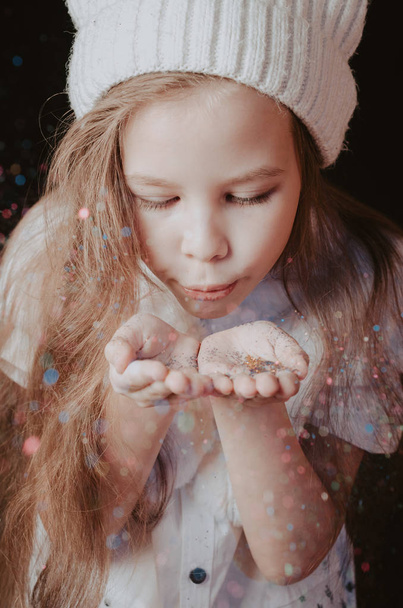 Little girl blowing on palm with sparkles - Photo, Image