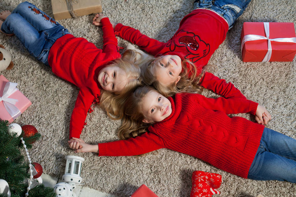 dwie blondynki małe dziewczyny leżą w pobliżu wakacje nowy rok prezenty choinkowe - Zdjęcie, obraz