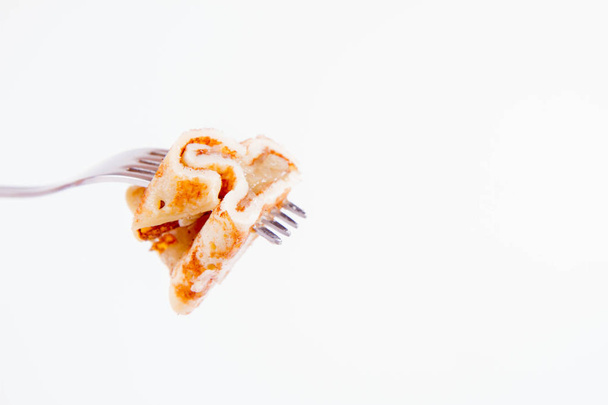 Pancakes stuffed with braised apples sprinkled with cinnamon on a fork - Фото, зображення