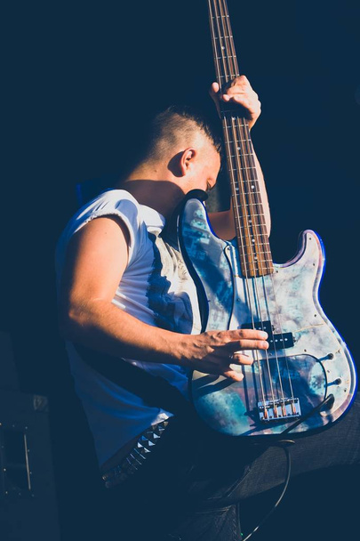 Vinnytsja, Oekraïne - 09.20.2015: Mykola Kolkov, bassist van Oekraïense punkrockband Cherry-Merry speelt zijn legendarische Fender Squier gitaar op het podium tijdens het muziekfestival Rock Brama - Foto, afbeelding
