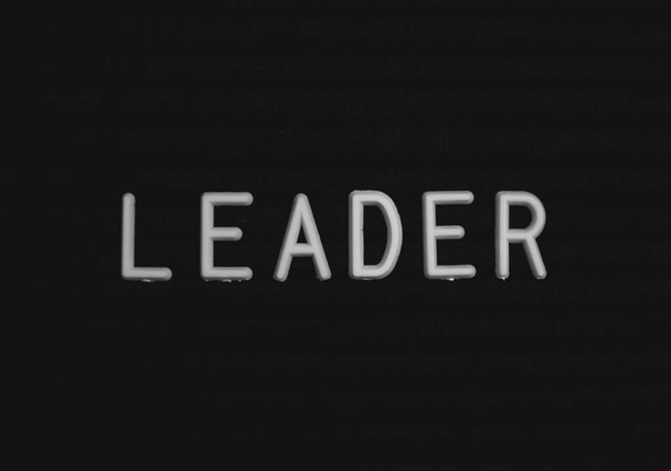 Slovo vůdce napsal na tabuli dopis. Bílá písmena na černém pozadí - Fotografie, Obrázek